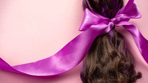 Dunkelbrauner Zopf mit Haarschleife in lila