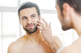 Strahlender Teint dank Antifaltencreme Mann trägt Anti-Aging Faltencreme auf